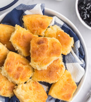 overhead view of touch of grace biscuits in a shallow bowl lined with a towel