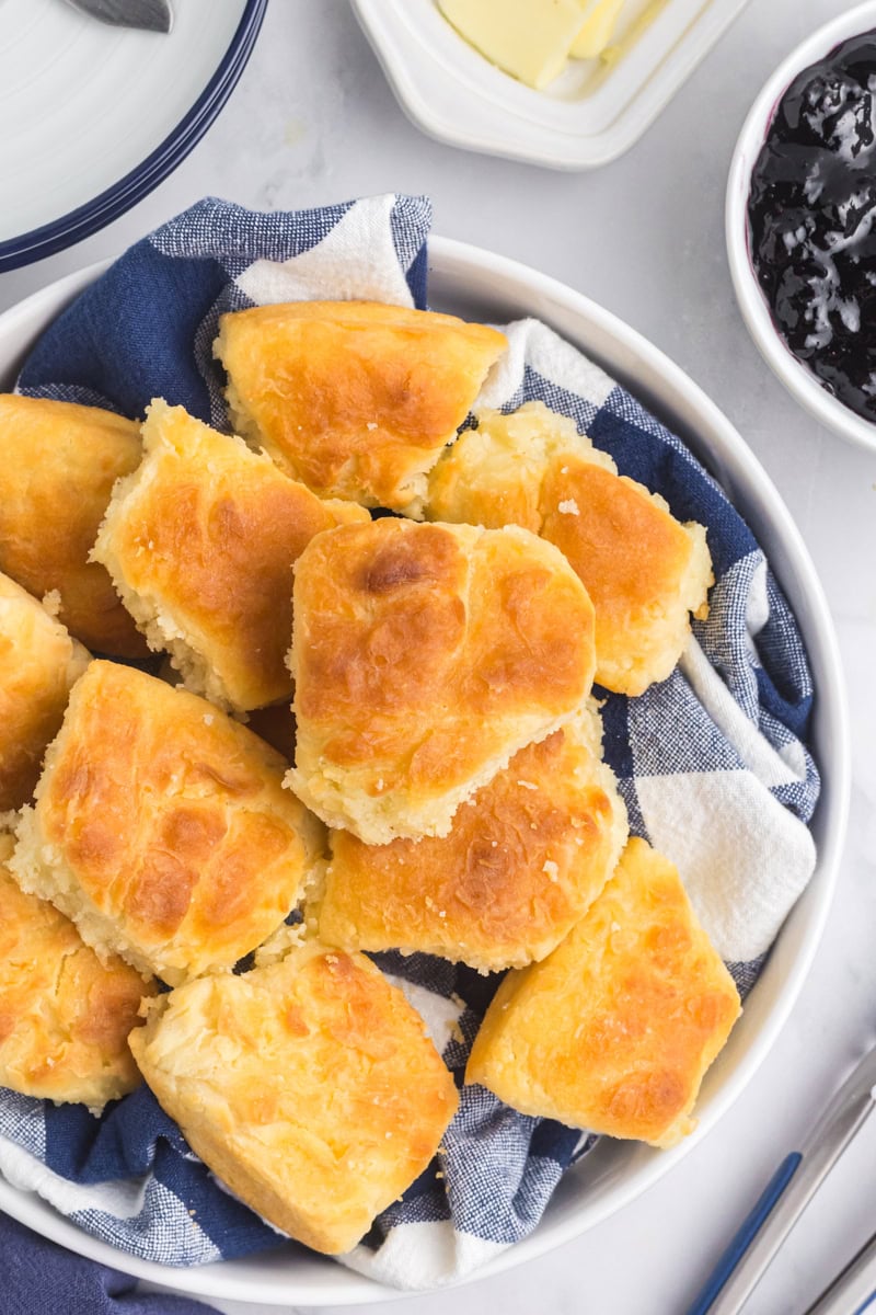 overhead view of touch of grace biscuits in a shallow bowl lined with a towel