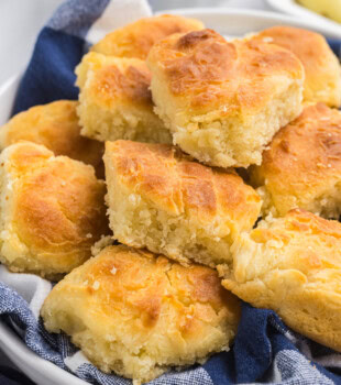 touch of grace biscuits piled in a towel-lined shallow white bowl