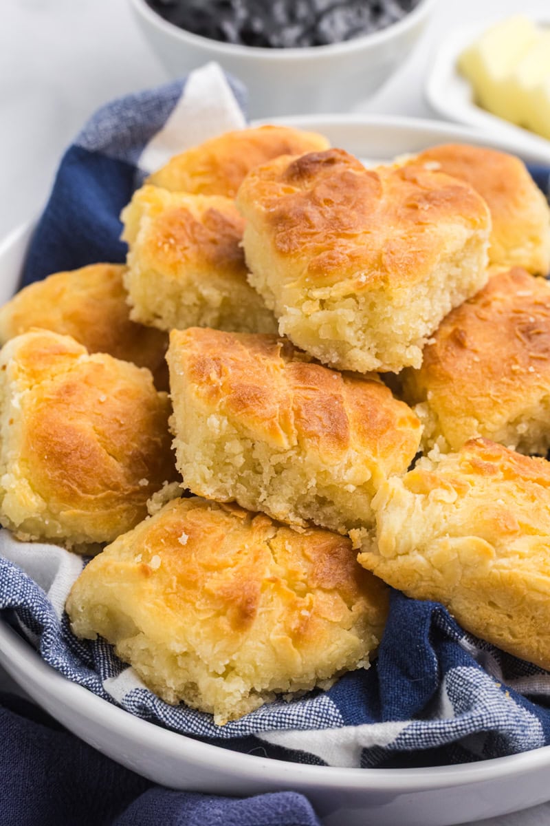 touch of grace biscuits piled in a towel-lined shallow white bowl