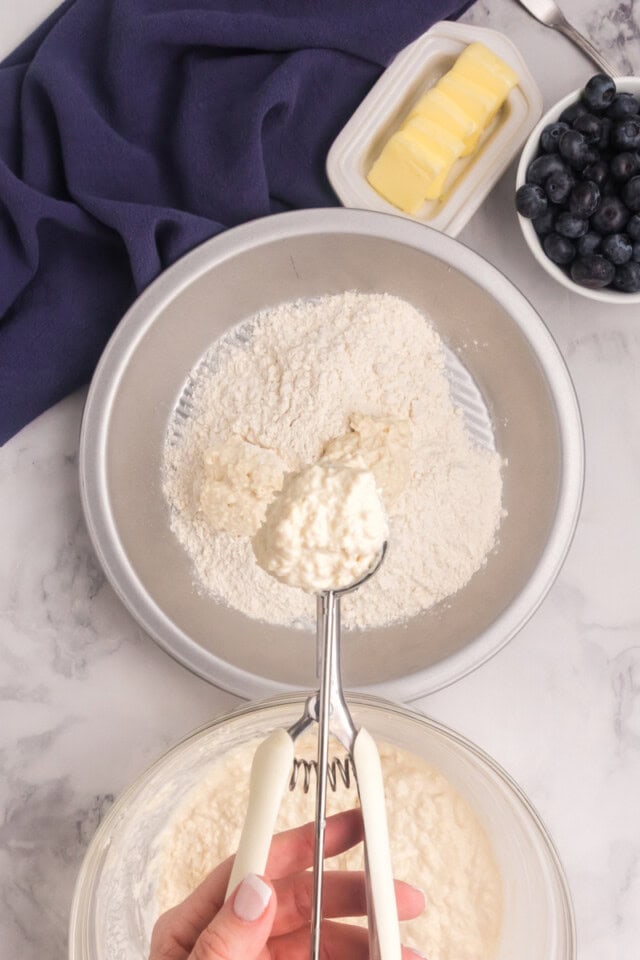 biscuit dough in a scoop ready to roll in flour