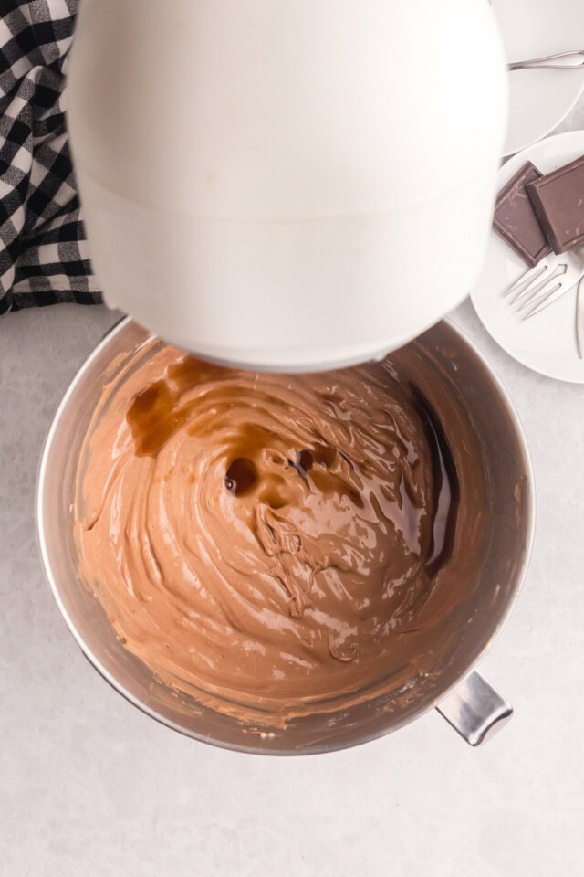 overhead view of vanilla extract added to chocolate cheesecake batter