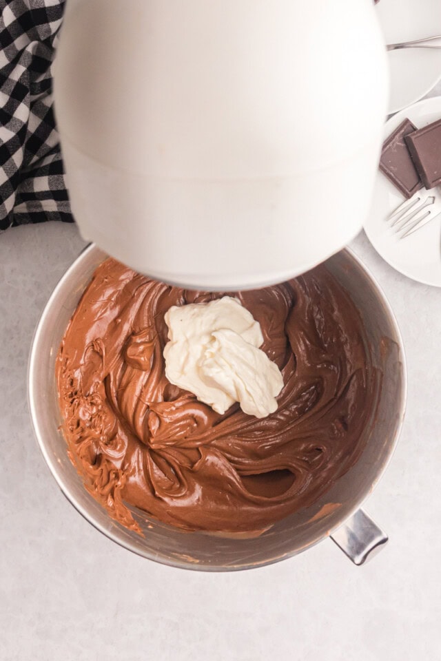 overhead view of sour cream added to chocolate cheesecake batter