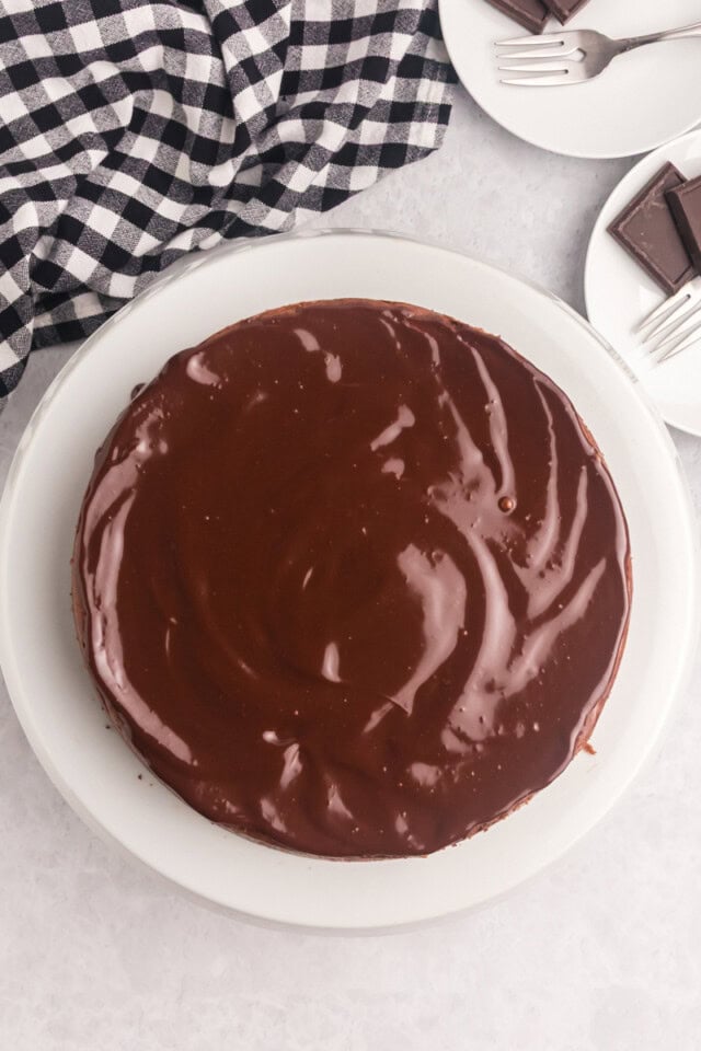 overhead view of chocolate ganache spread over brownie bottom chocolate cheesecake