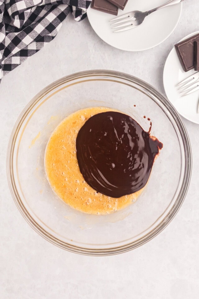 overhead view of melted chocolate and butter added to a mixture of sugars, egg, and vanilla