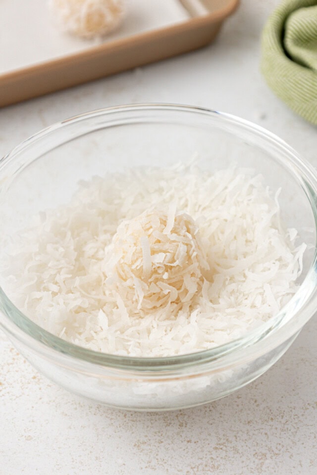 a coconut snowball in a bowl of shredded coconut