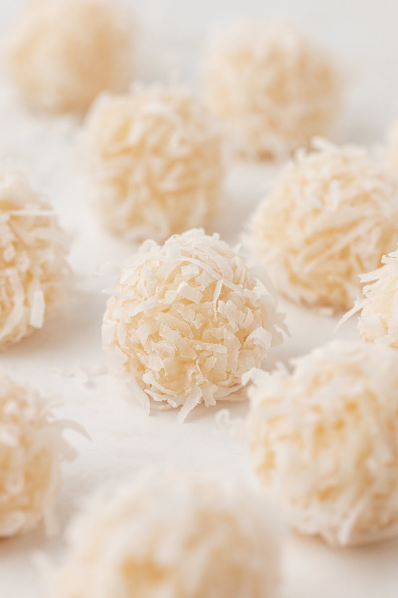 close up of coconut snowballs on a white surface