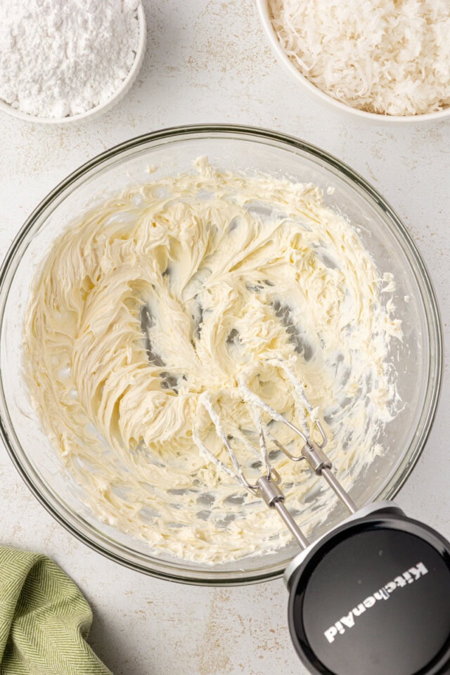 overhead view of beaten cream cheese in a glass mixing bowl