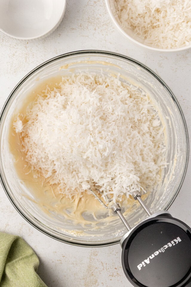 overhead view of shredded coconut added to cream cheese mixture for coconut snowballs