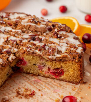partially sliced cranberry coffee cake on parchment paper