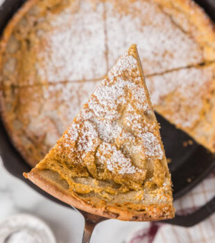 overhead view of a slice of Dutch baby pancake lifting away from the remaining pancake