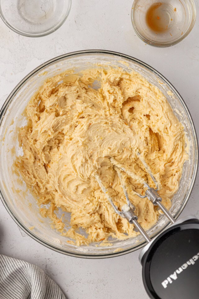 overhead view of orange cookie dough in a mixing bowl