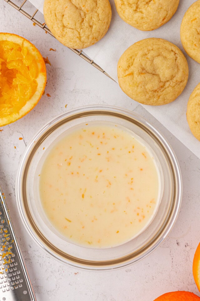 overhead view of orange icing in a glass bowl