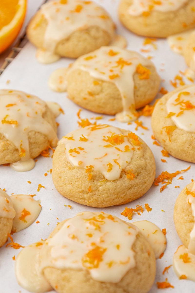 glazed orange cookies on white parchment paper