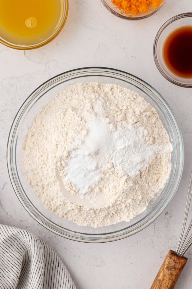 overhead view of flour, baking powder, baking soda, and salt in a mixing bowl