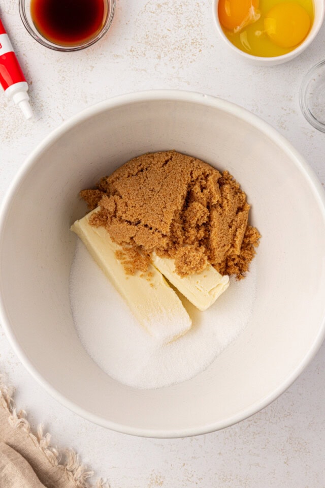 overhead view of butter, sugar, and brown sugar in a white mixing bowl