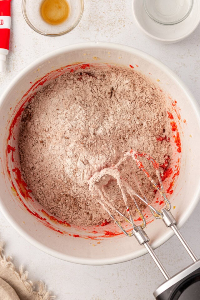 overhead view of dry ingredients added to wet ingredients for red velvet cookies