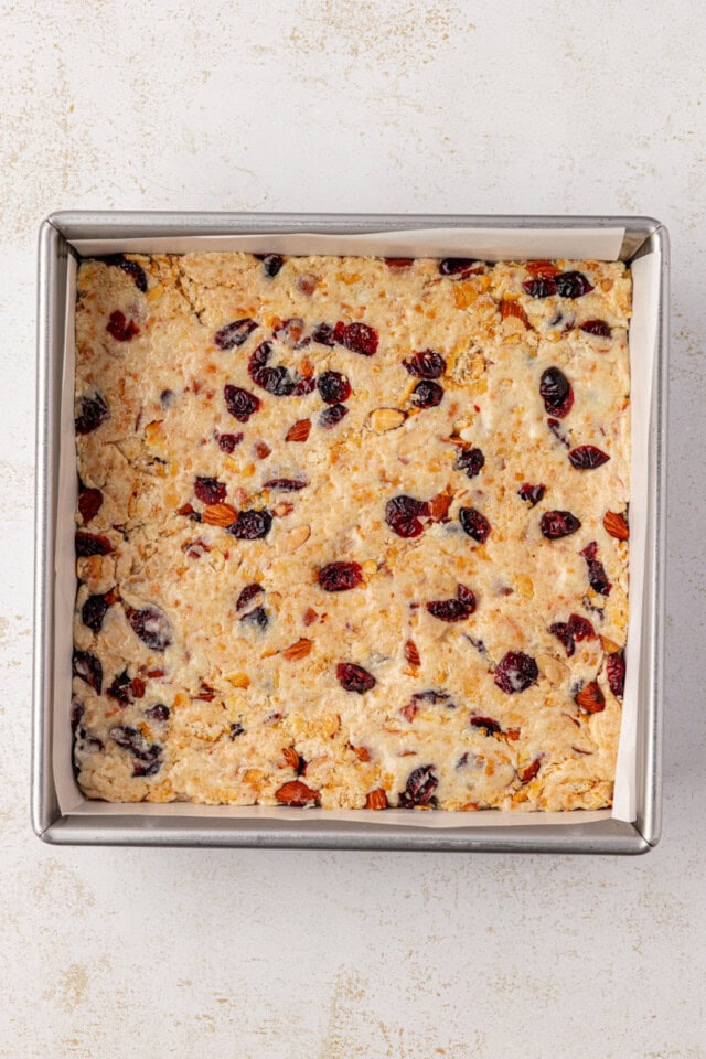 overhead view of snowflake crisp mixture spread in a lined baking pan