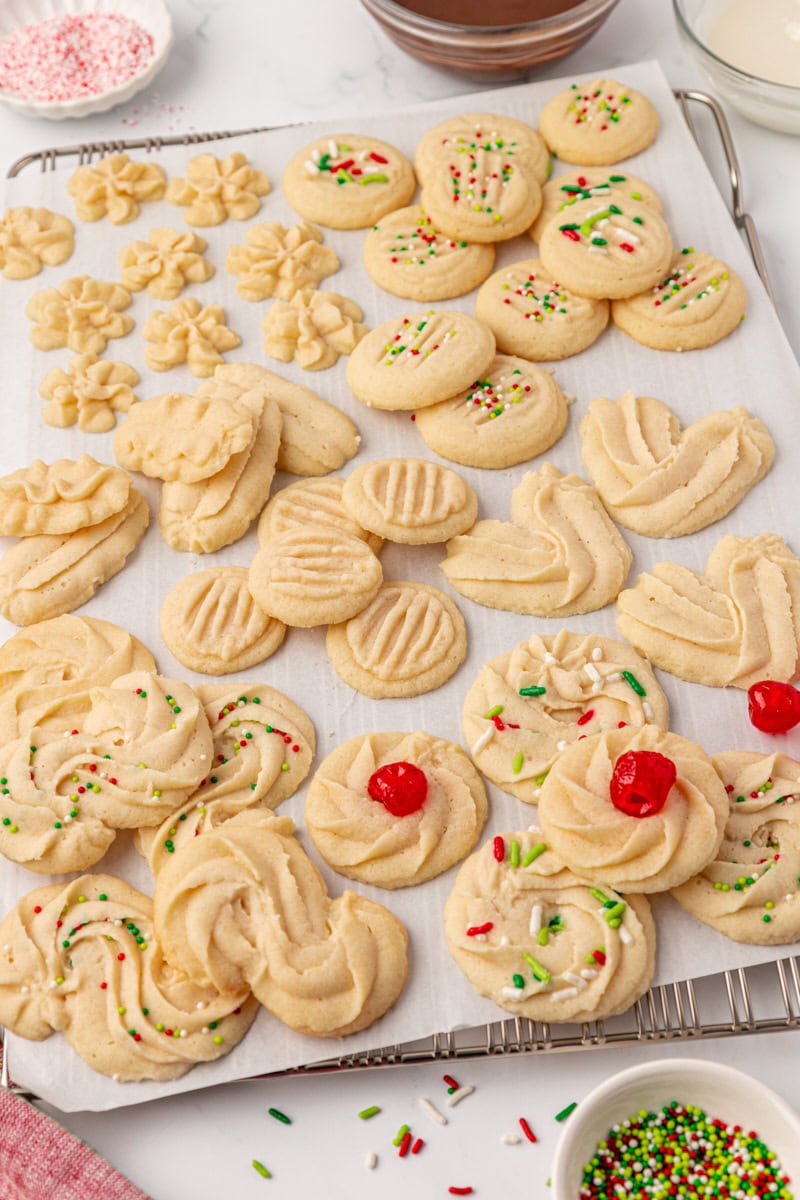 whipped shortbread cookies in various shapes and styles on parchment paper