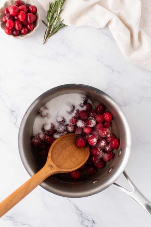overhead view of cranberries, sugar, and water in a saucepan