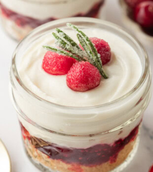 close up of a no-bake white chocolate cranberry cheesecake jar on a white surface