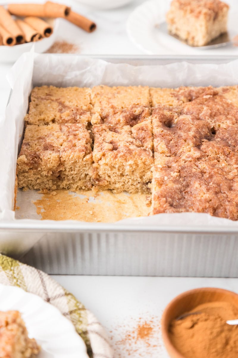 slices of cinnamon sugar snack cake in a parchment lined baking pan