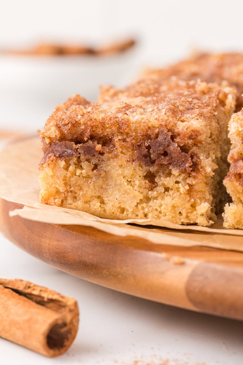 closeup of a slice of cinnamon sugar snack cake on a wooden cutting board