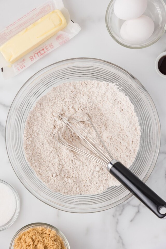 overhead view of flour, baking powder, cinnamon, and salt combined in a mixing bowl
