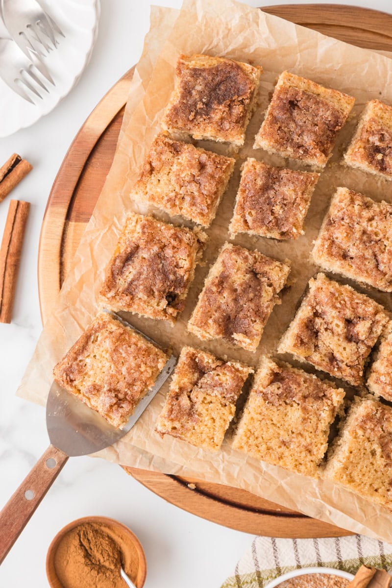 overhead view of slices of cinnamon sugar snack cake on parchment paper
