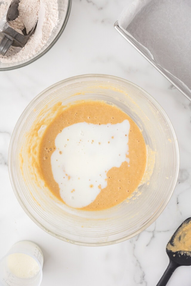 overhead view of buttermilk added to cake batter