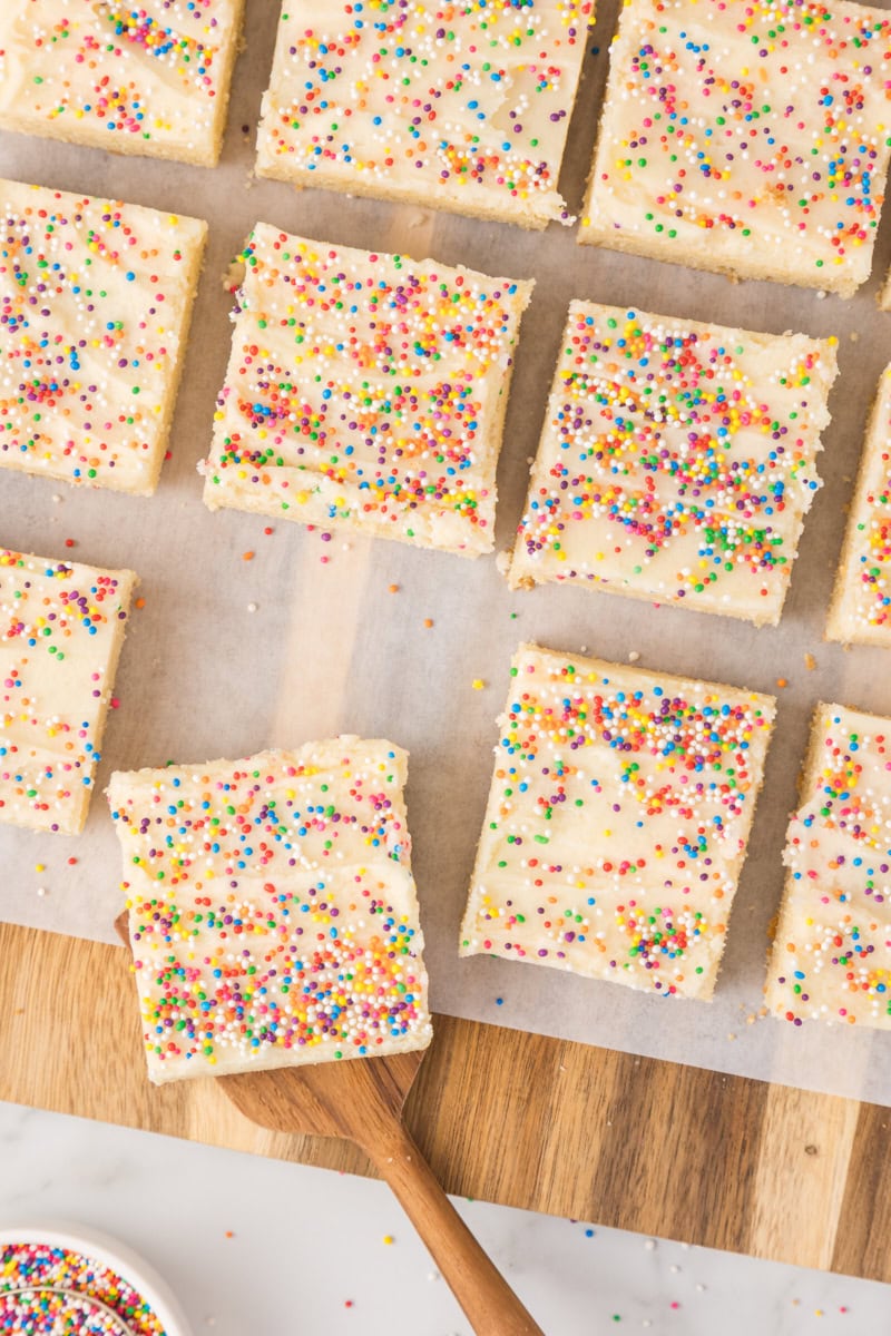 overhead view of frosted sugar cookie bars on a wooden board