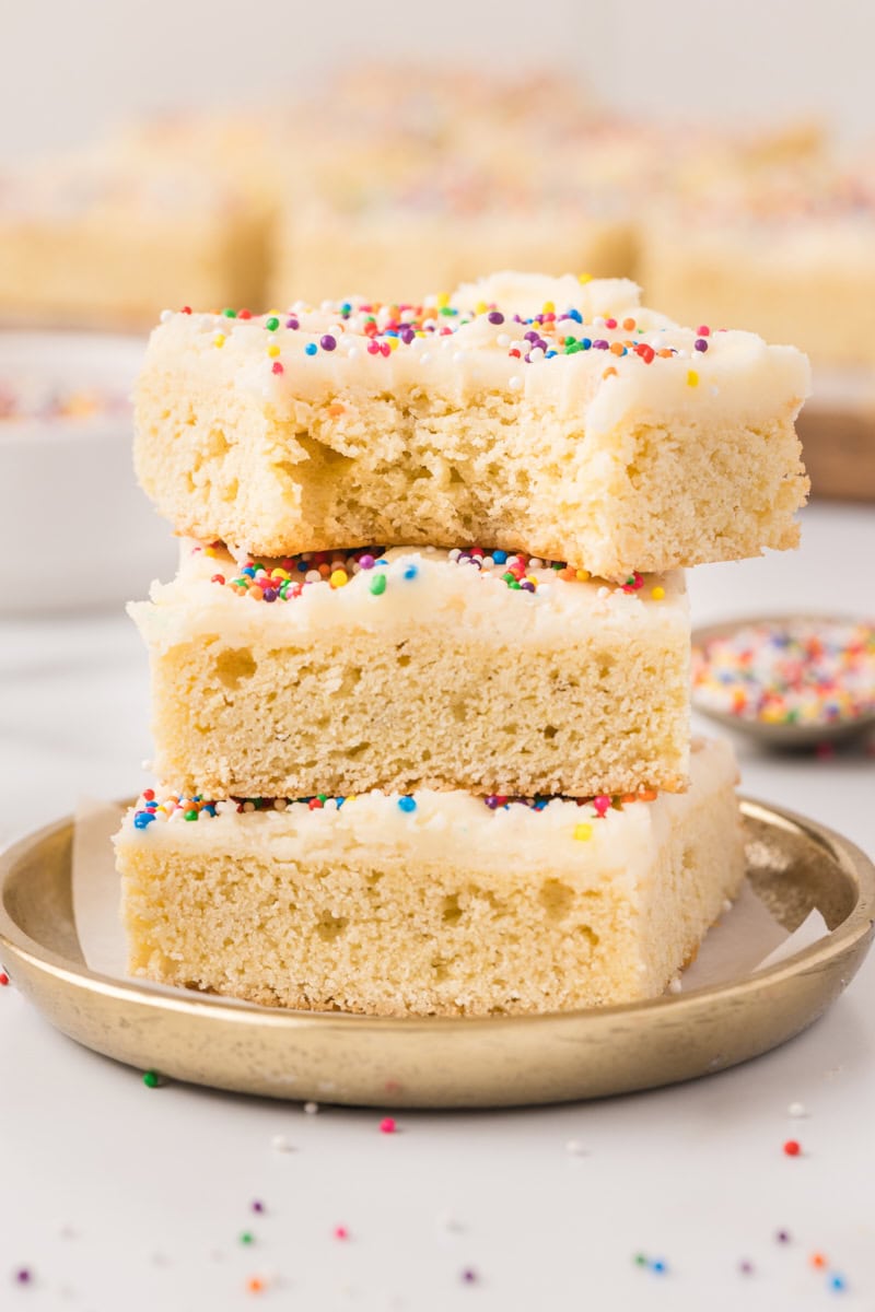 stack of three frosted sugar cookie bars with a bite missing from the top bar