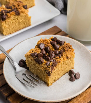 a slice of peanut butter chocolate chip cake on a plate with more cake slices in the background