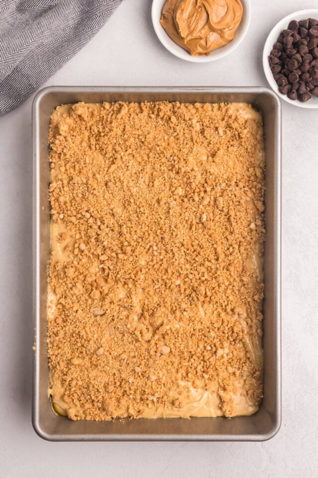overhead view of crumb mixture sprinkled over peanut butter snack cake batter