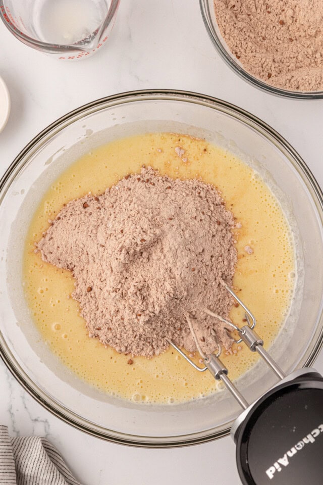 overhead view of dry ingredients added to wet ingredients for red velvet cake