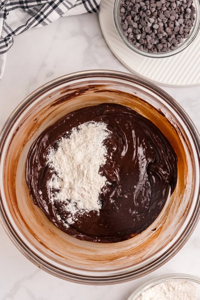 overhead view of dry ingredients added to wet ingredients for chocolate cookies