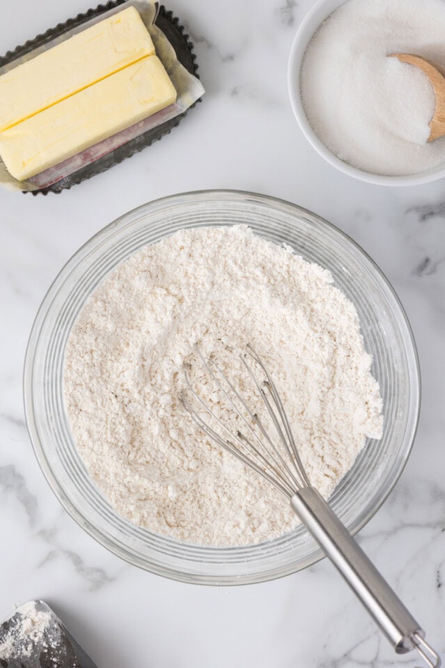 overhead view of flour, baking powder, baking soda, and salt whisked together in a mixing bowl