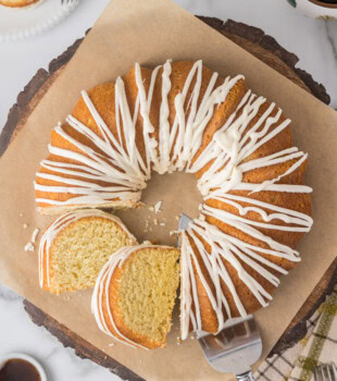 overhead view of partially sliced vanilla Bundt cake topped with a vanilla bean glaze