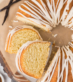 partially sliced vanilla Bundt cake topped with a smooth vanilla glaze