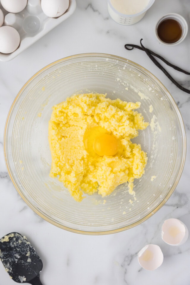overhead view of egg added to creamed butter and sugar