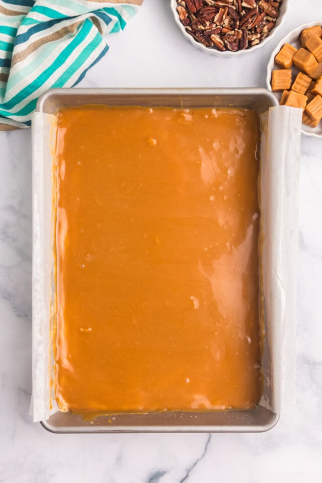 overhead view of caramel layer spread over buttery crust for caramel cheesecake bars