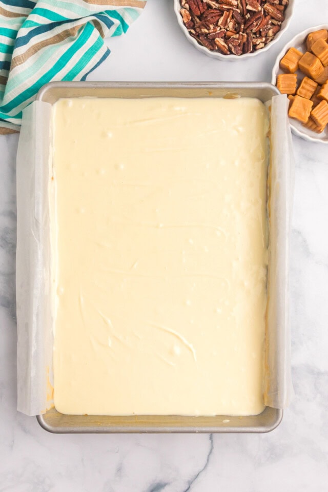 overhead view of cheesecake filling spread over caramel layer and shortbread crust