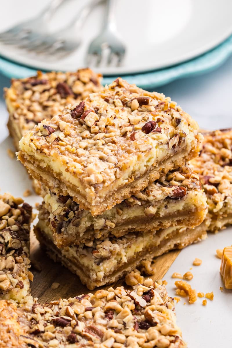 stack of three layered cheesecake bars with caramel and toffee topping