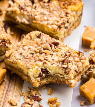 close-up of a caramel cheesecake bar showing gooey caramel layer