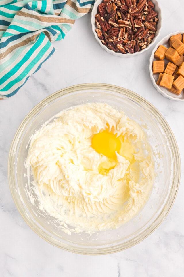 overhead view of egg added to cream cheese mixture for cheesecake filling