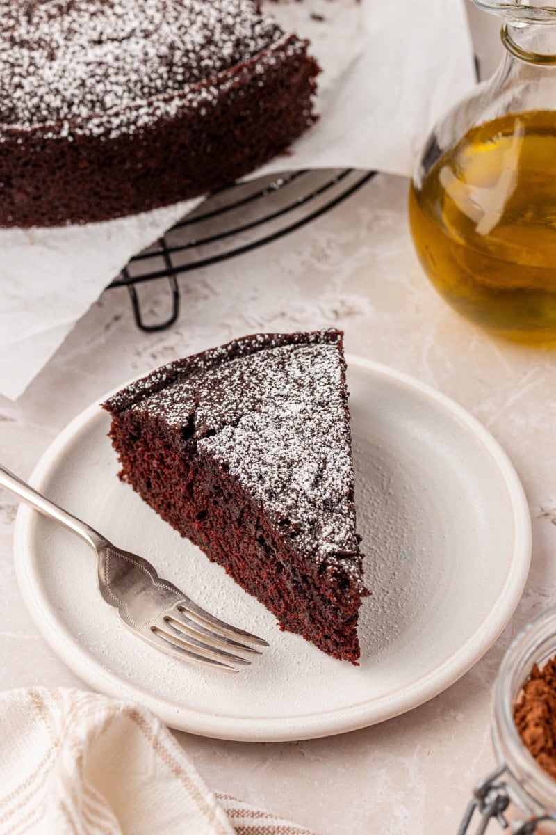 a slice of chocolate olive oil cake on a white plate
