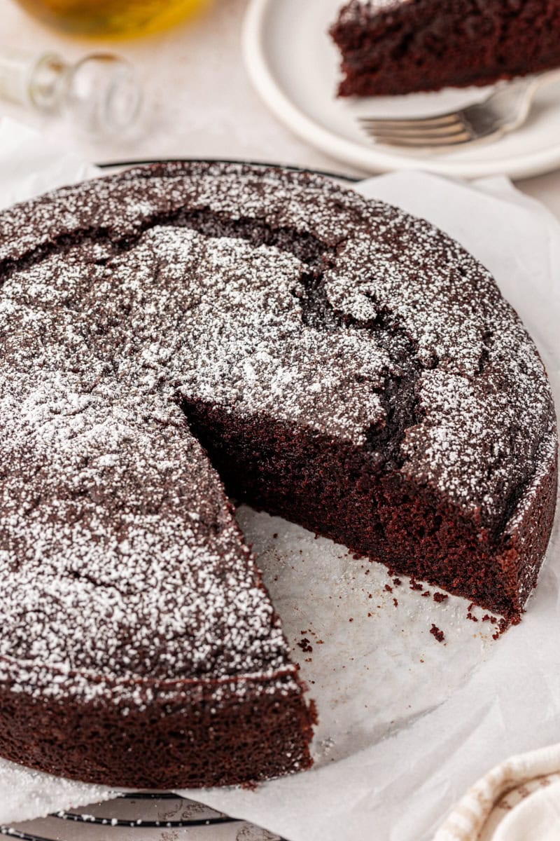 chocolate olive oil cake partially sliced to show the soft cake texture