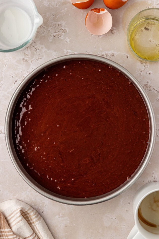 overhead view of chocolate olive oil cake in a round cake pan ready to go into the oven