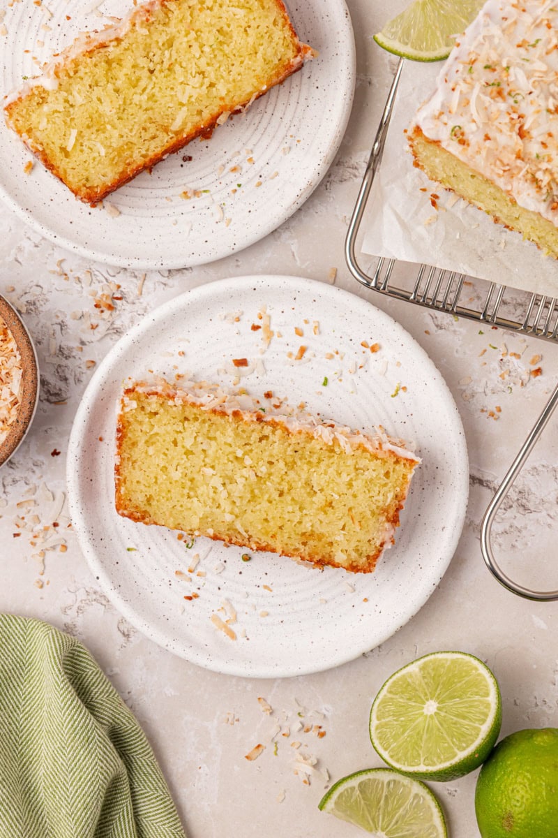 slice of coconut lime cake topped with lime glaze, toasted coconut, and lime zest