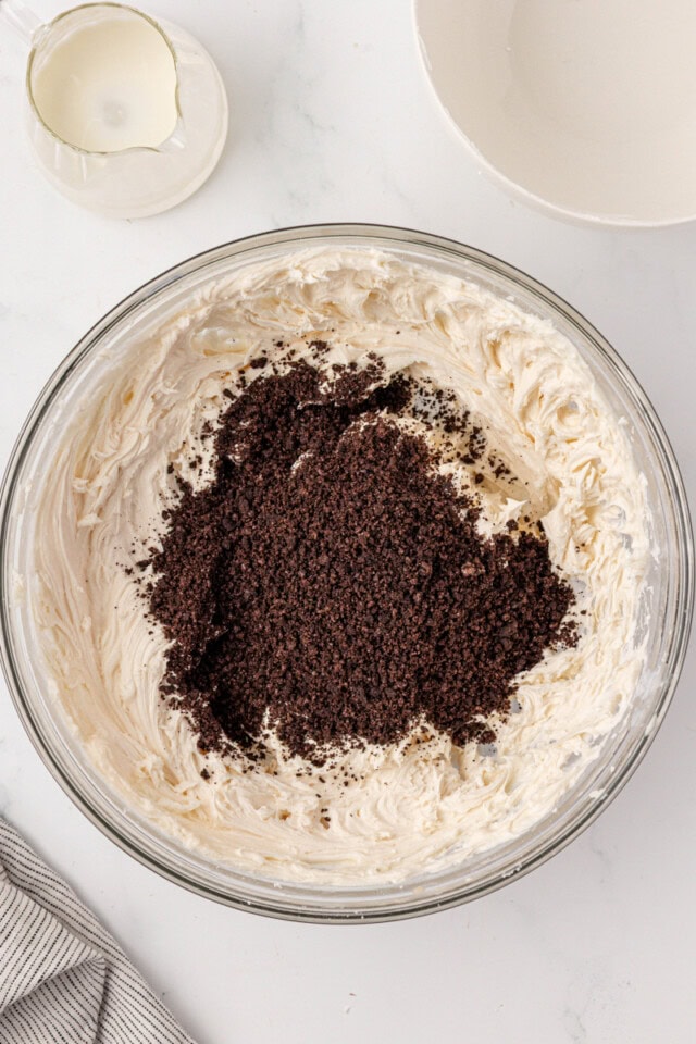 overhead view of chocolate sandwich cookie crumbs added to vanilla buttercream